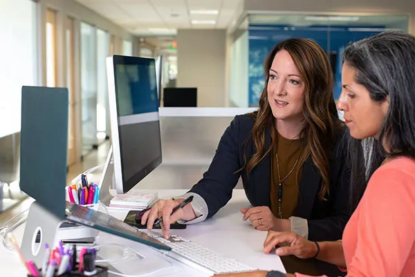 Two people using a computer at an office