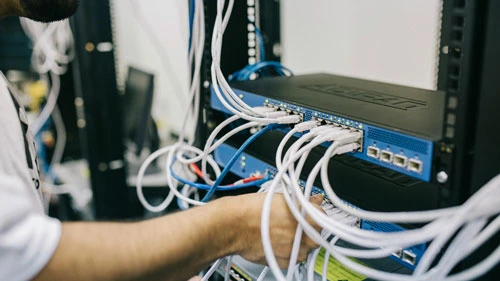 Person attaching cables to a network switch