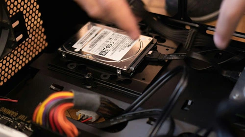 Technician installing a hard drive inside a computer