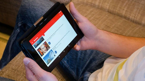 Person sitting holding a tablet