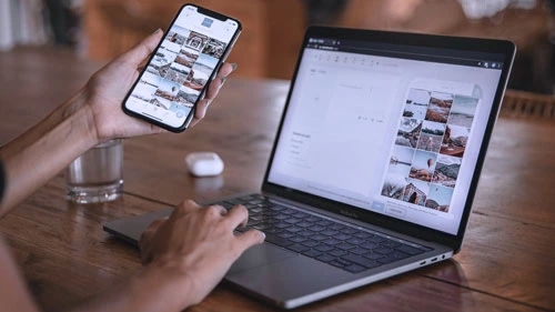 A person looking at their phone an laptop with their project displayed